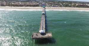 Aerial shot of Anglin's Pier extending towards the beach
